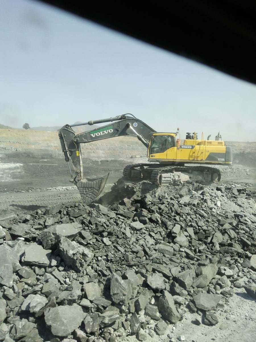 Excavator loading rock